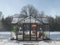 Elegant black T-shaped Lakeside Orangerie greenhouse in a garden setting.